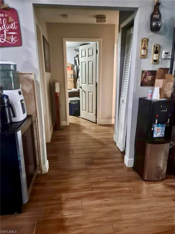 Wood-finish flooring throughout a hallway with painted walls