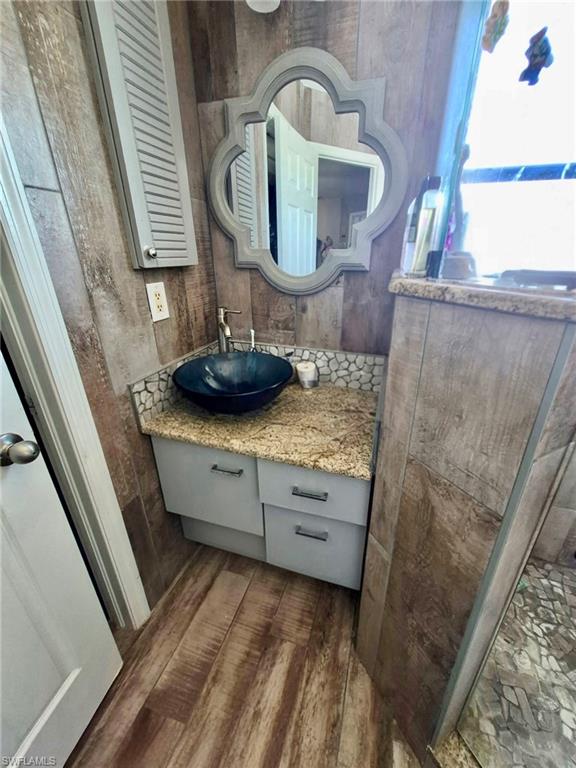 Vanity with granite countertop, vessel sink, and chrome faucet