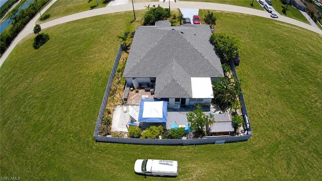 Property featuring a gray shingle roof, a fenced perimeter, and a rear patio area