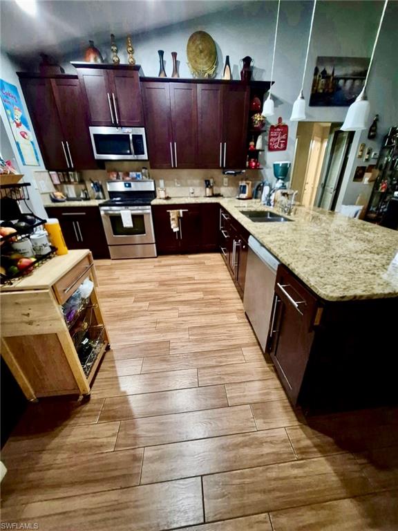 Kitchen featuring wood-finish flooring, dark wood cabinetry, and speckled countertops