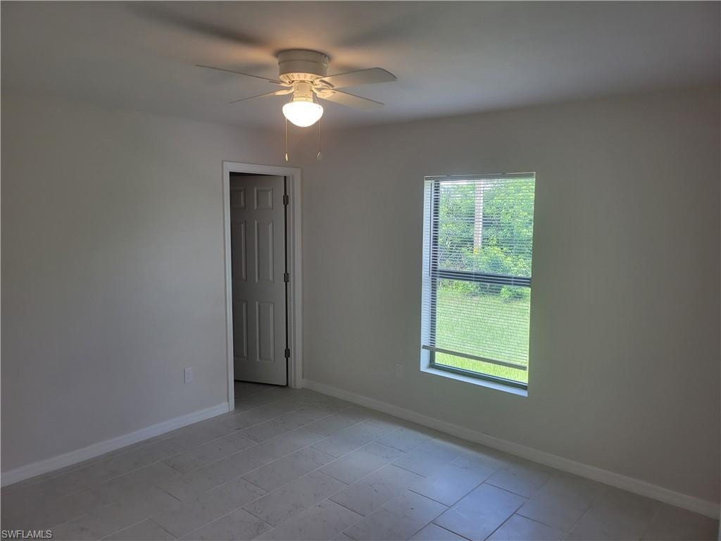 Unfurnished room featuring ceiling fan and light tile patterned floors