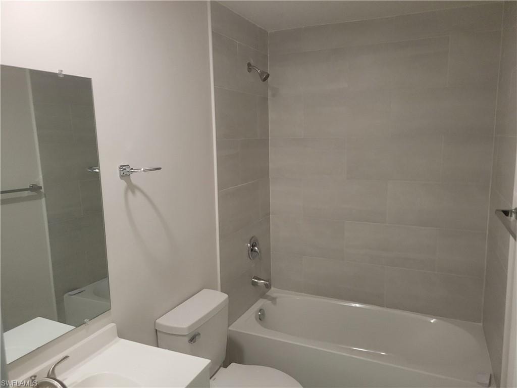 Full bathroom featuring vanity, toilet, and tiled shower / bath