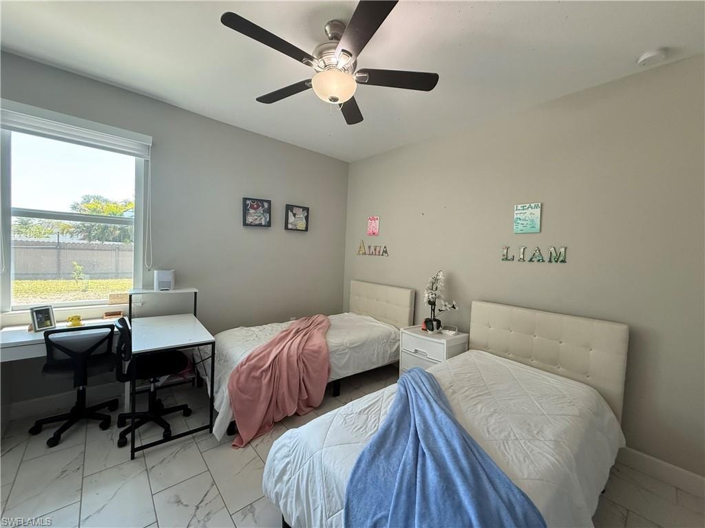 Bedroom featuring a ceiling fan with integrated lighting, a window with exterior views, and neutral wall tones