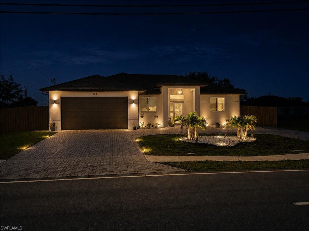 Contemporary exterior with integrated uplighting and a paver driveway