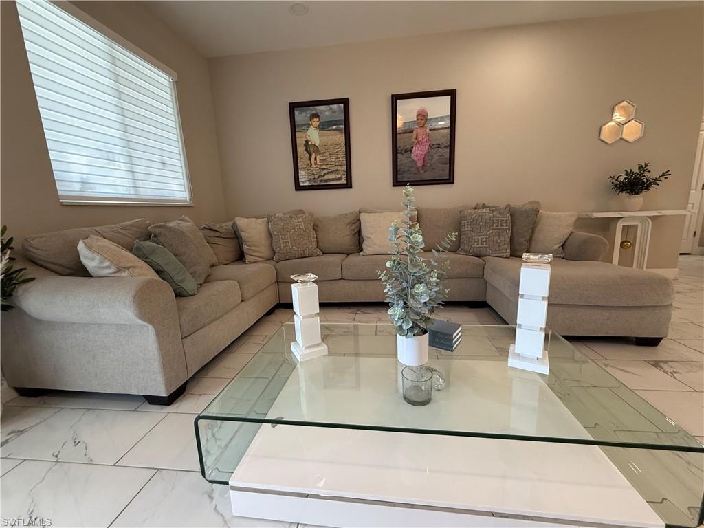 Spacious living area featuring large format tile flooring, recessed lighting, and a window with horizontal blinds