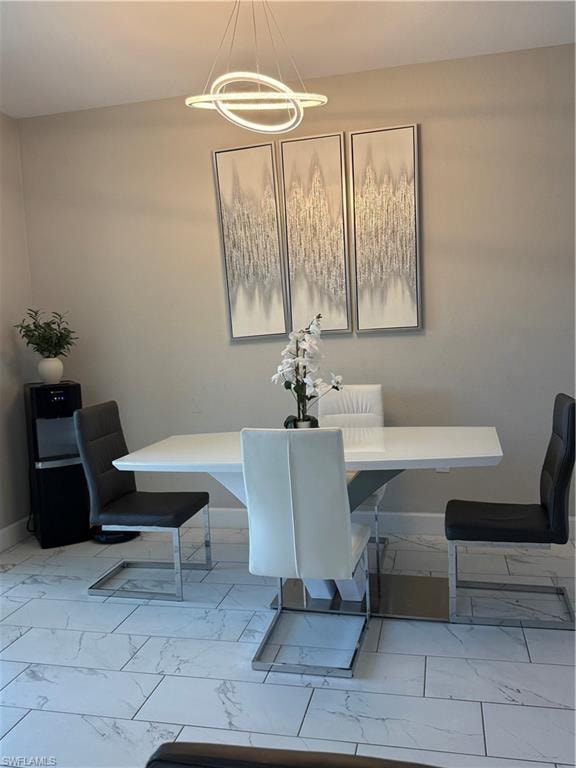 Modern chandelier lighting over a white dining table