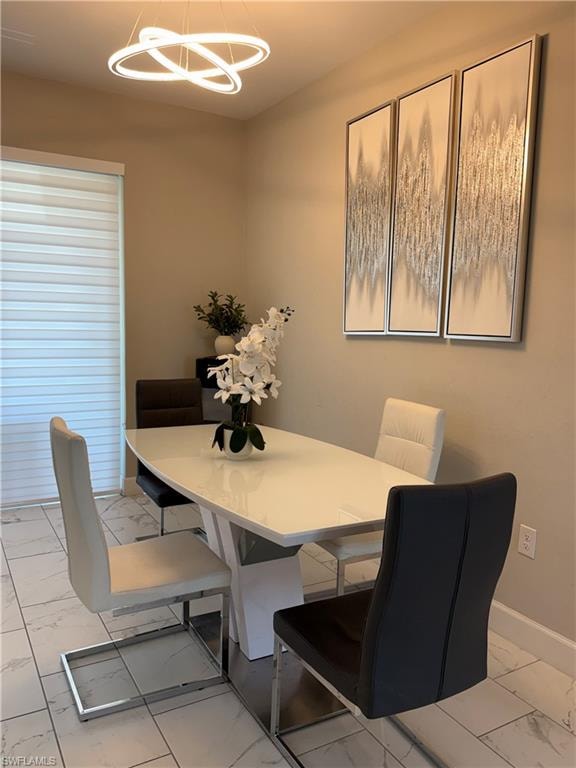 Dining area featuring a contemporary chandelier, neutral wall color, and tile flooring