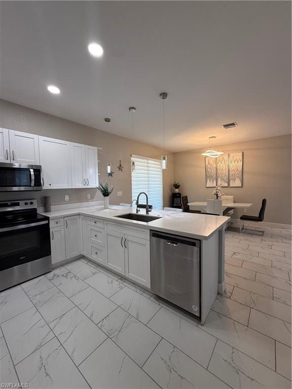 Modern kitchen featuring white cabinetry, light-toned countertops, stainless steel appliances, and large format tile flooring