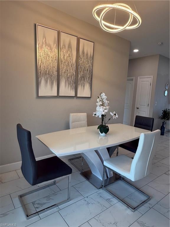 Modern dining space featuring a contemporary chandelier and recessed lighting