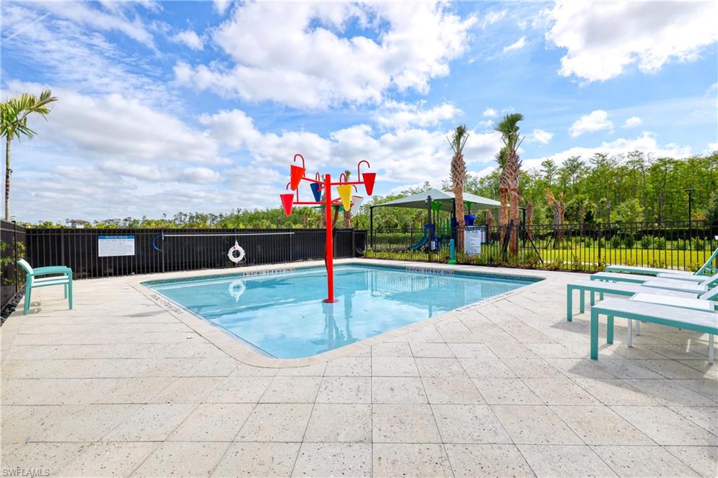 Pool with fence, a patio area, and playground community