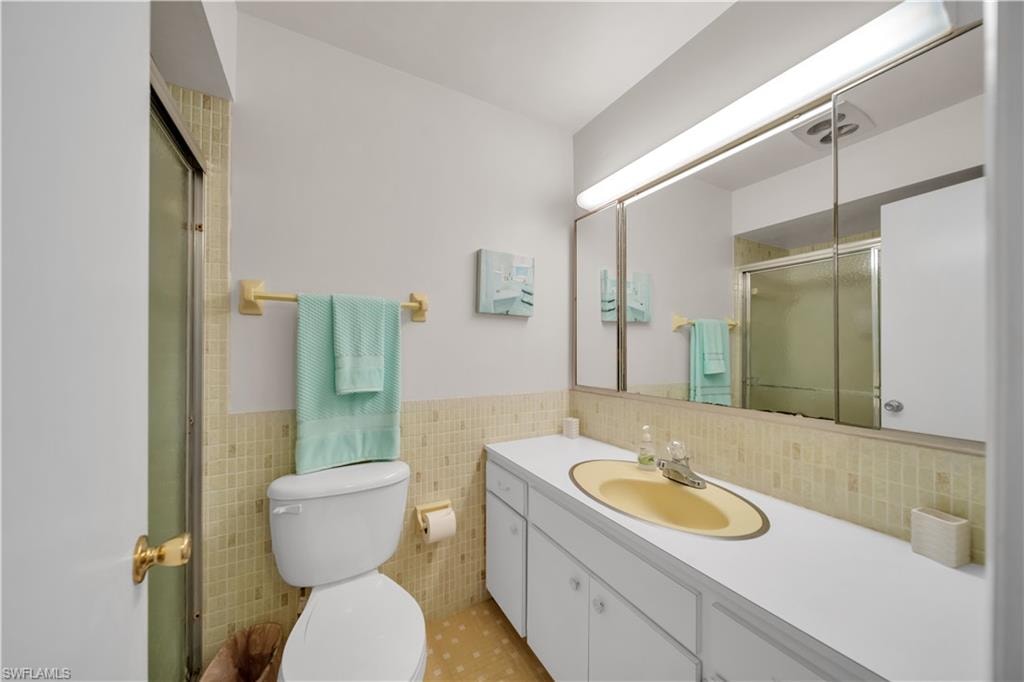 Bathroom featuring an integrated vanity with a yellow oval sink, white countertop, and white cabinetry