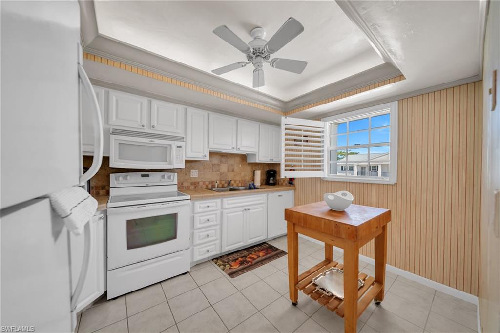 Kitchen featuring white cabinetry, a light-colored countertop, and a tiled backsplash