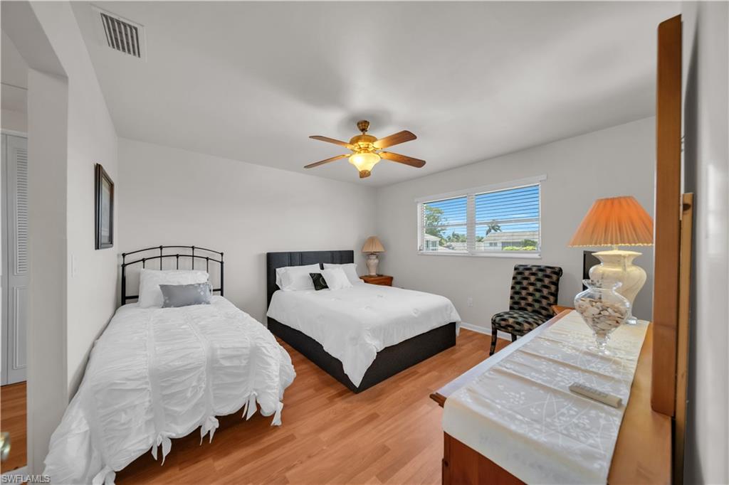 Bedroom featuring wood-finish flooring, a ceiling fan, and white walls