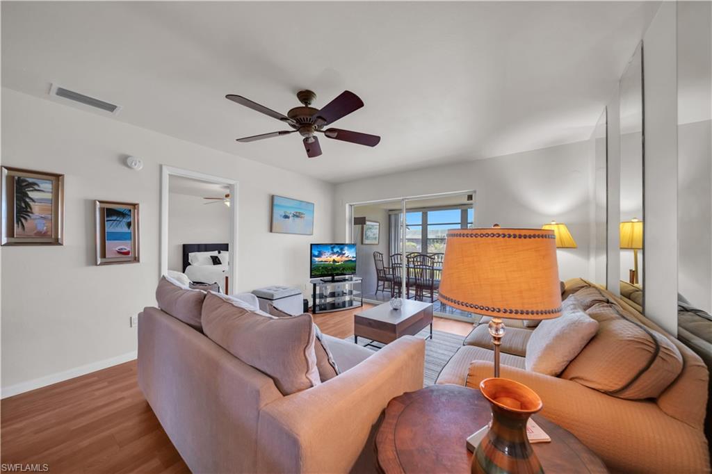 Living area featuring wood-finish flooring, a ceiling fan, and sliding glass door access to an exterior space