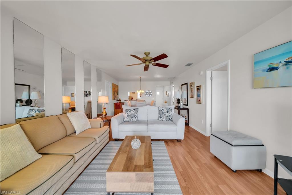 Spacious living area featuring wood-finish flooring, a ceiling fan, and recessed lighting
