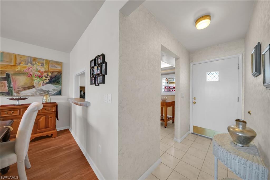 Entryway featuring a white door with diamond-patterned glass, light-toned floor tiling, and a flush-mount ceiling light