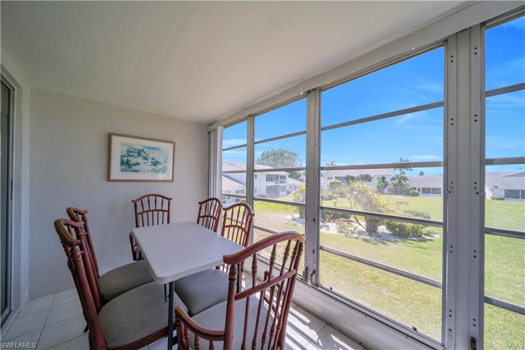 Enclosed patio featuring floor-to-ceiling windows, white tile flooring, and light-colored walls