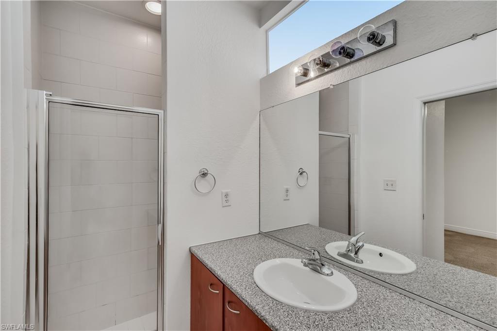 Bathroom featuring vanity with extensive cabinet space and an enclosed shower