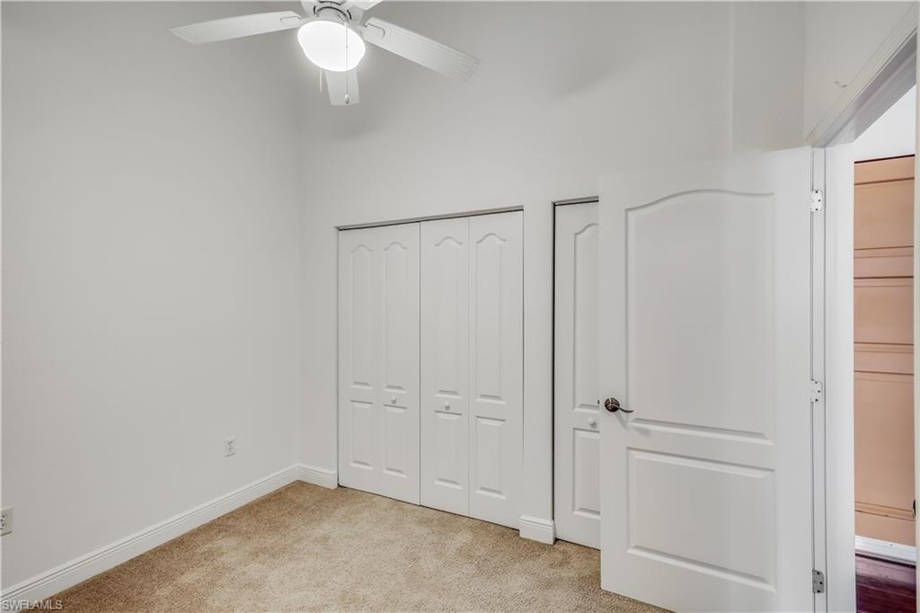 Unfurnished bedroom featuring light carpet and ceiling fan