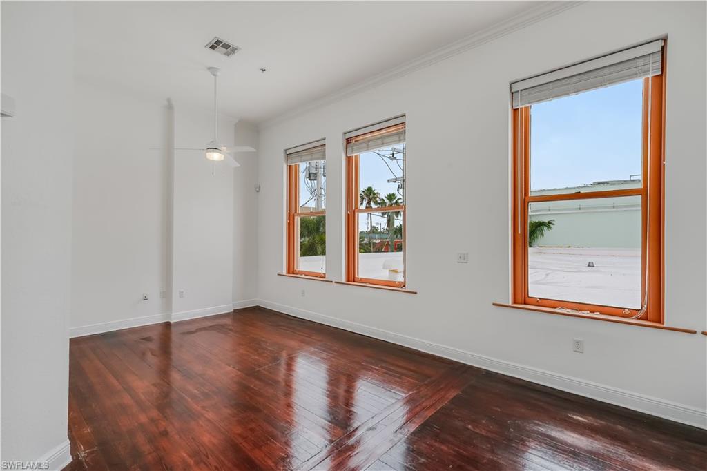 Unfurnished room with ornamental molding, dark hardwood / wood-style floors, and ceiling fan