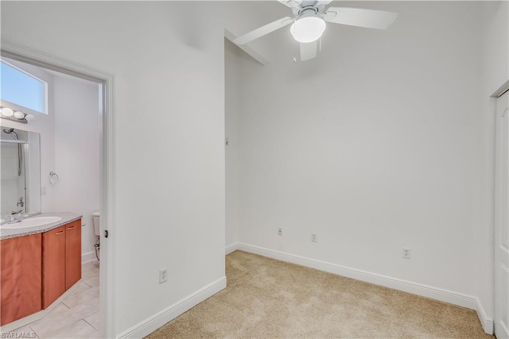Carpeted bedroom with sink and ceiling fan