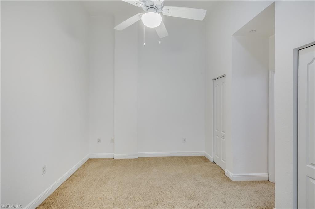 Carpeted spare room featuring ceiling fan