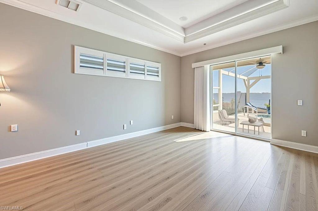 OWNER'S BEDROOM W/LUXURY VINYL FLOORING & SLIDERS TO LANAI & RIVER VIEW