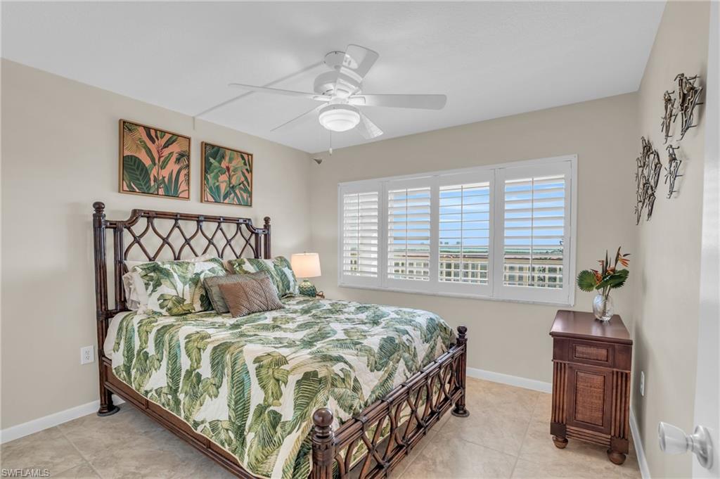 Window with white plantation shutters overlooking a distant horizon, complemented by tiled flooring and a ceiling fan
