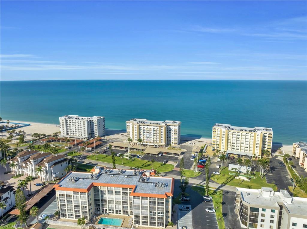 Waterfront property featuring multiple buildings, direct beach access, and an outdoor swimming pool