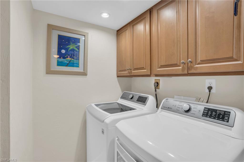 Laundry area featuring wood-finish cabinetry, white wall paint, and recessed ceiling lighting