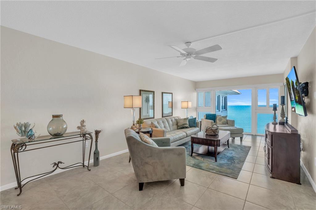 Living area featuring tile flooring, a ceiling fan, and floor-to-ceiling windows