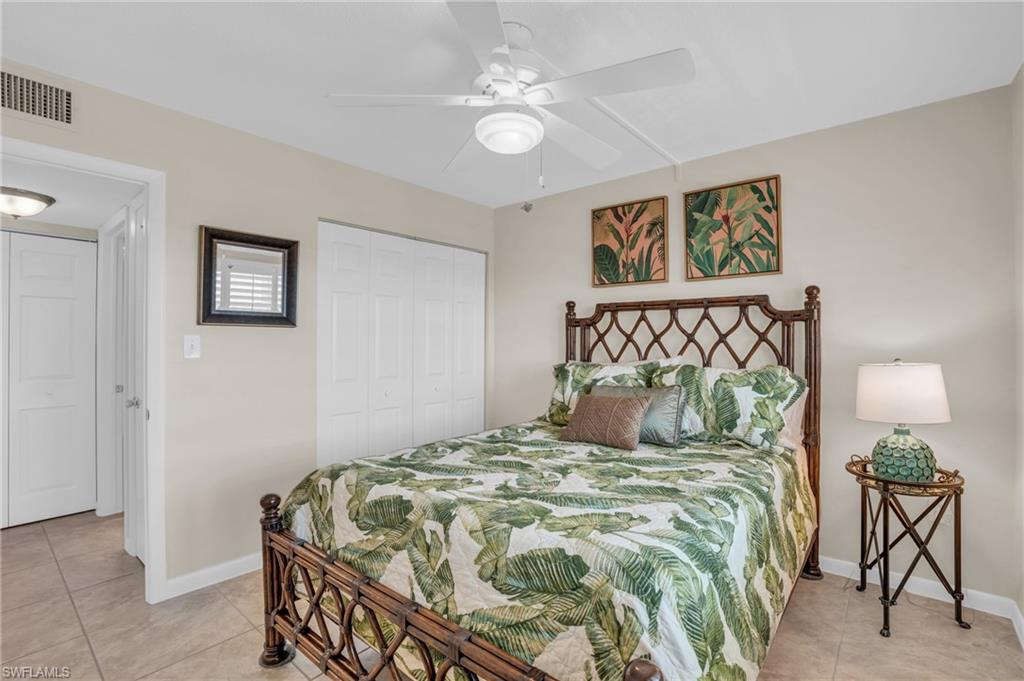 Bedroom featuring a decorative headboard, neutral wall paint, and a built-in ceiling fan with integrated lighting