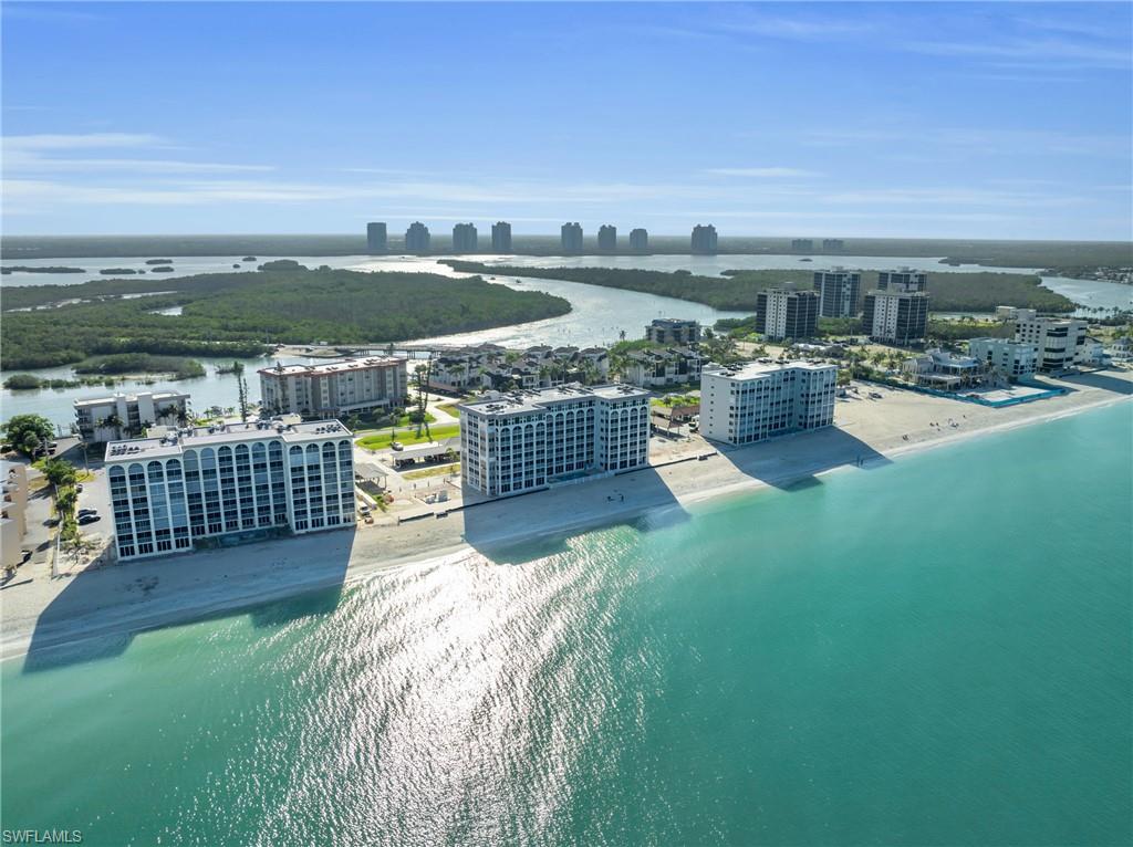 Coastal beachfront properties featuring direct beach access, white sand, and turquoise waters