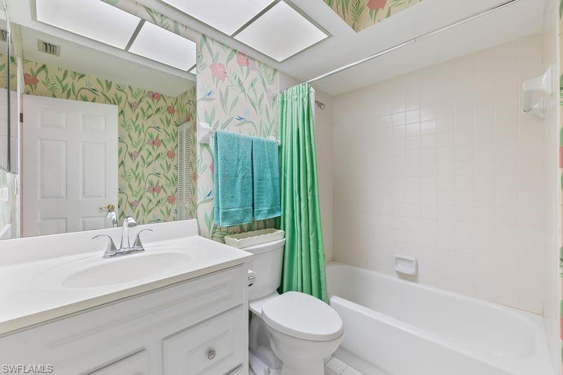 Bathroom vanity with white cabinet, integrated sink, and tub/shower combo.