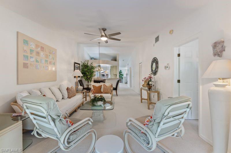 Living area featuring light-toned carpeting and vaulted ceilings, and new ceiling fan.