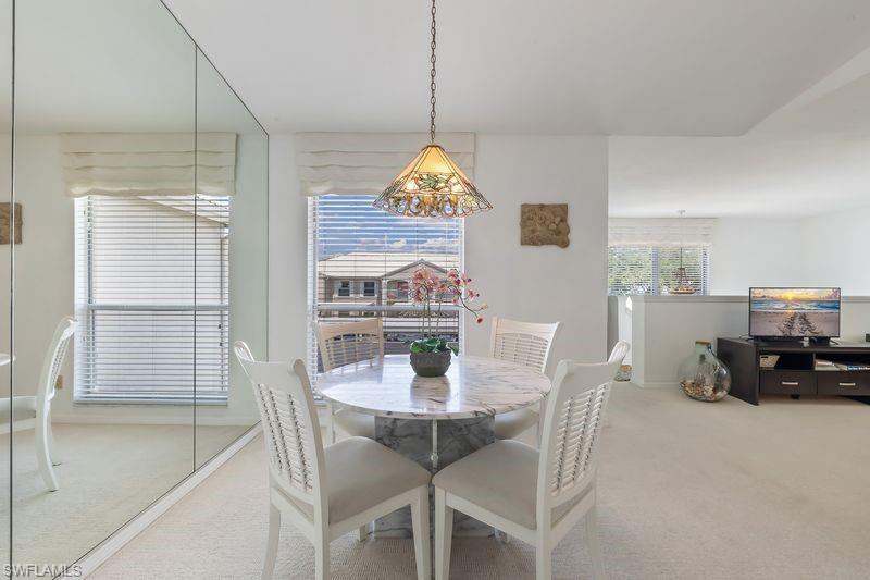 Dining area featuring a decorative pendant lighting, and a mirrored wall panel.