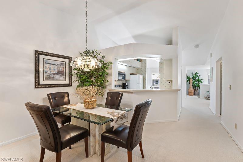 Dining/Living area featuring overhead chandelier lighting, and vaulted ceilings.