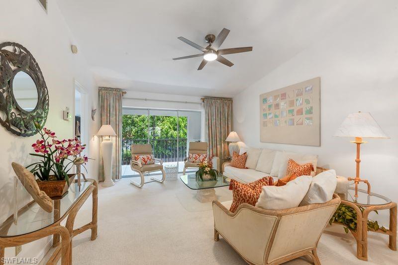 Living space featuring a neutral color palette, new ceiling fan with integrated lighting, and a glass sliding door opening to a private screened lanai area.