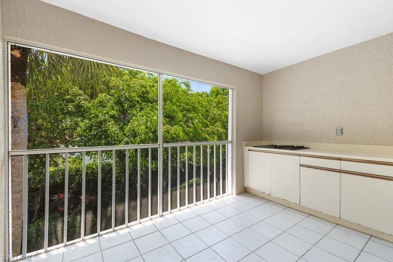 Screened lanai area with tiled flooring, built-in cabinets, and outdoor cooking area.