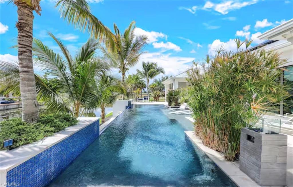 View of swimming pool with an infinity pool and patio surround