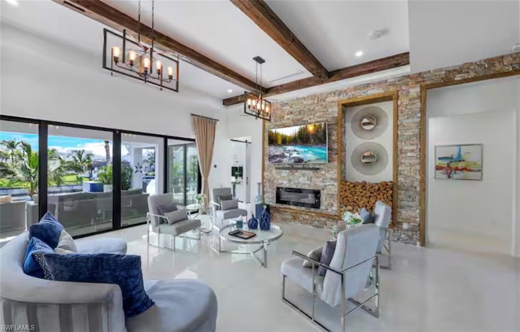 Living area featuring a fireplace, suspended lighting, and finished concrete flooring
