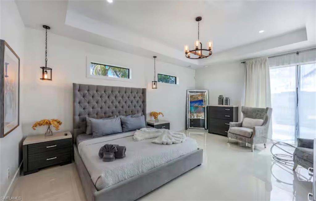 Bedroom featuring a raised ceiling and suspended lighting