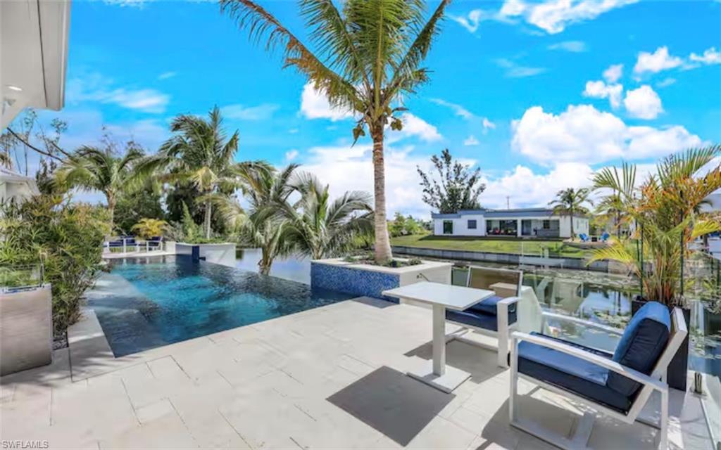 View of pool with patio surround and an infinity pool