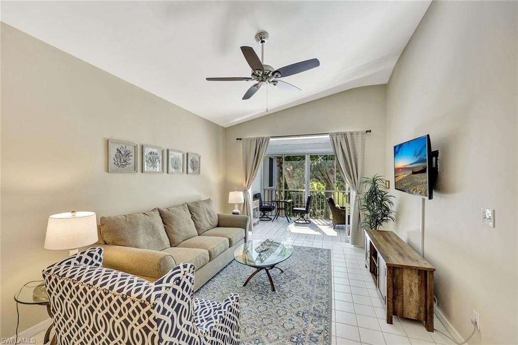 Living area featuring vaulted ceilings, light tile flooring, and direct access to a screened porch