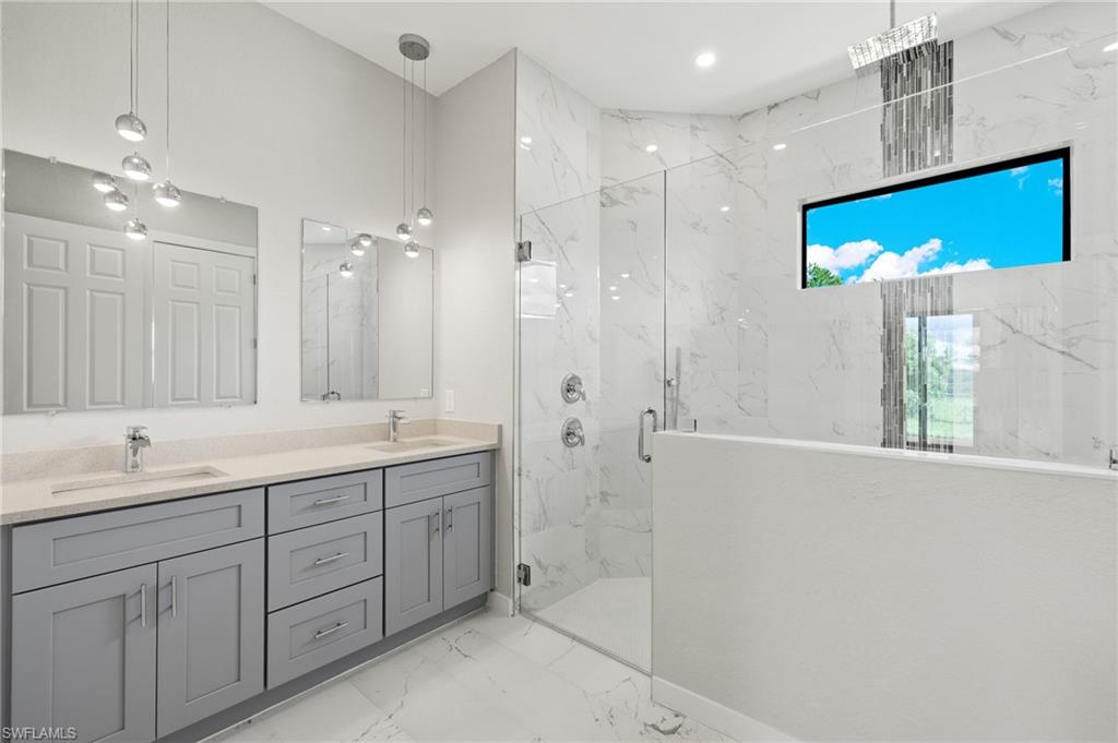 En-suite bathroom with dual quartz vanities, premium lighting & custom XL shower