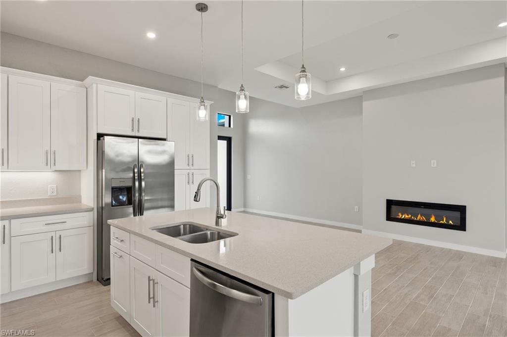 Gourmet kitchen with quartz island, shaker cabinets, and premium luxury vinyl plank (LVP) flooring upgrade.