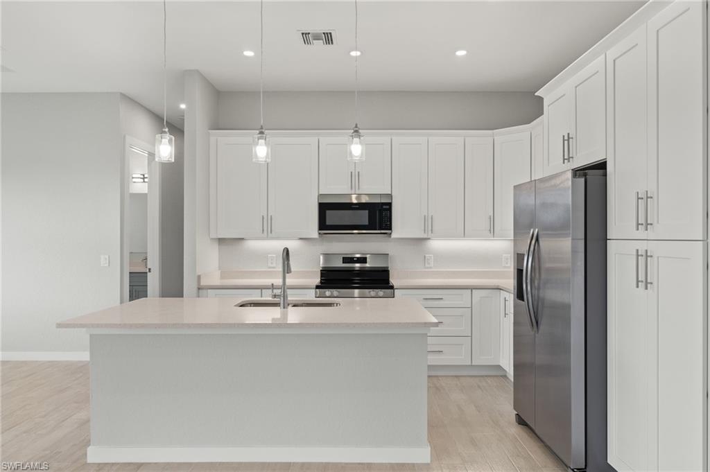 Gourmet kitchen with quartz island, shaker cabinets, and premium luxury vinyl plank (LVP) flooring upgrade.