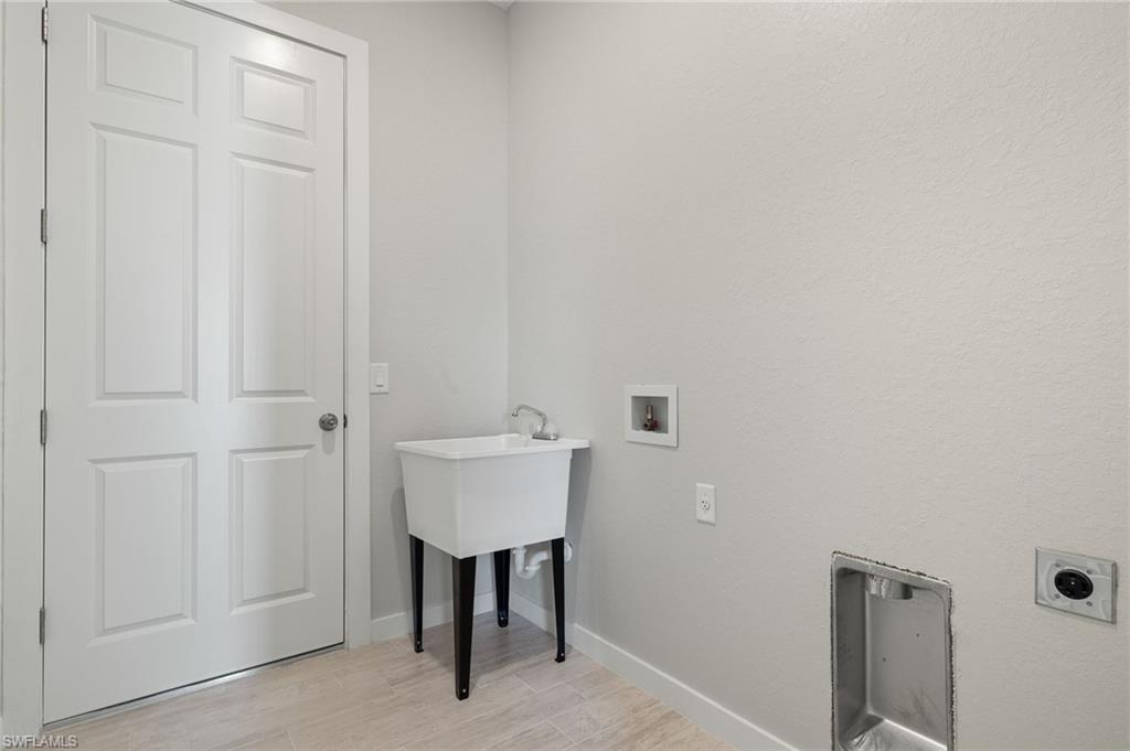 Laundry room with Laundry tub. Flooring upgraded to premium, color-matched Luxury Vinyl Plank [LVP].
