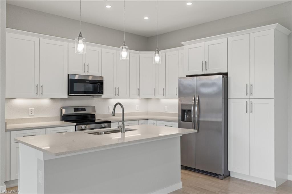 Gourmet kitchen with quartz island, shaker cabinets, and premium luxury vinyl plank (LVP) flooring upgrade.