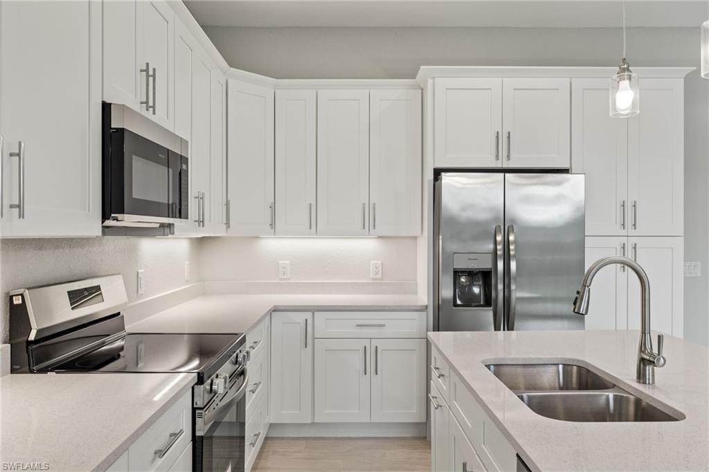 Gourmet kitchen with quartz island, shaker cabinets, and premium luxury vinyl plank (LVP) flooring upgrade.